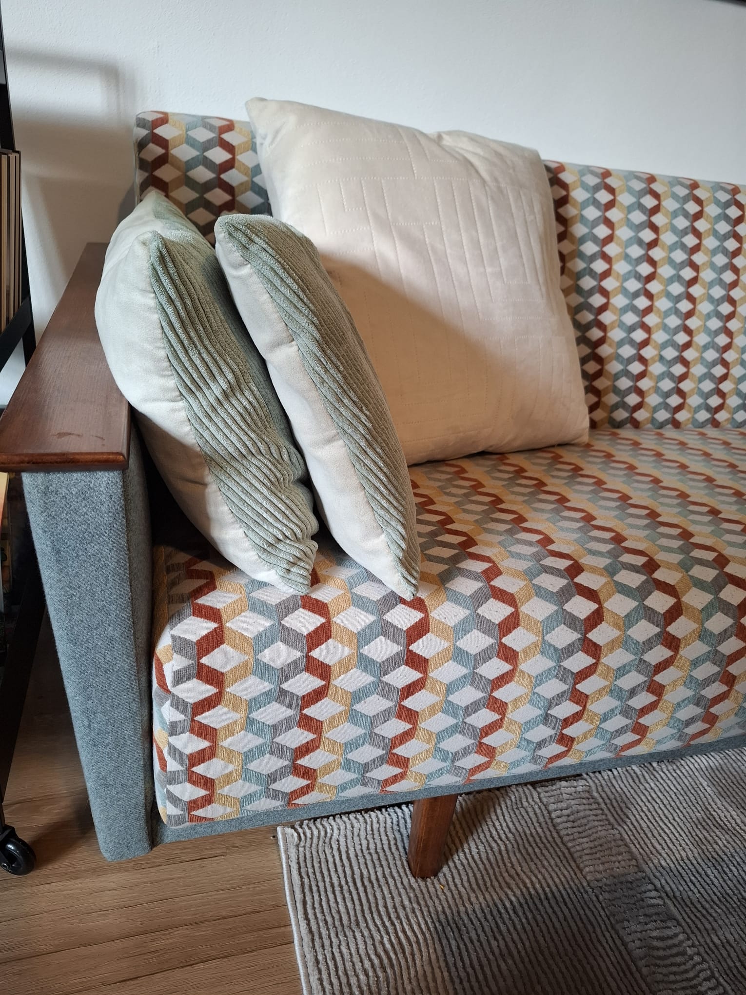 Detail prečalúnenej retro pohovky s moderným vzorom a vankúšmi
