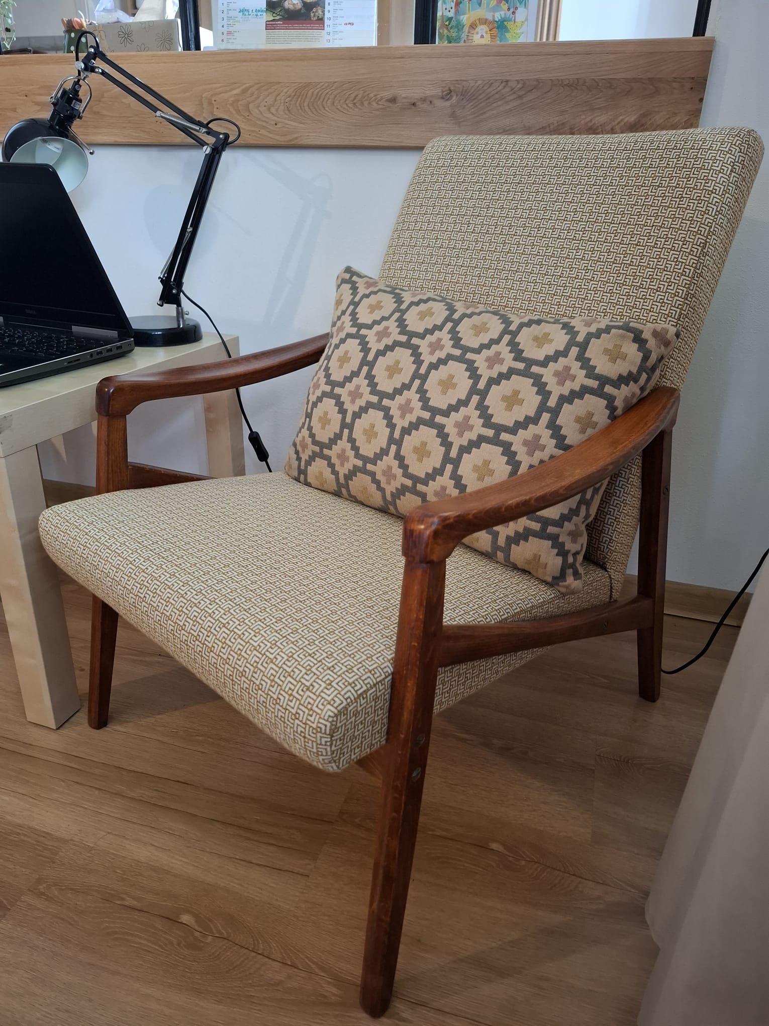 Detail prečalúneného retro kresla s modernou látkou a vankúšom